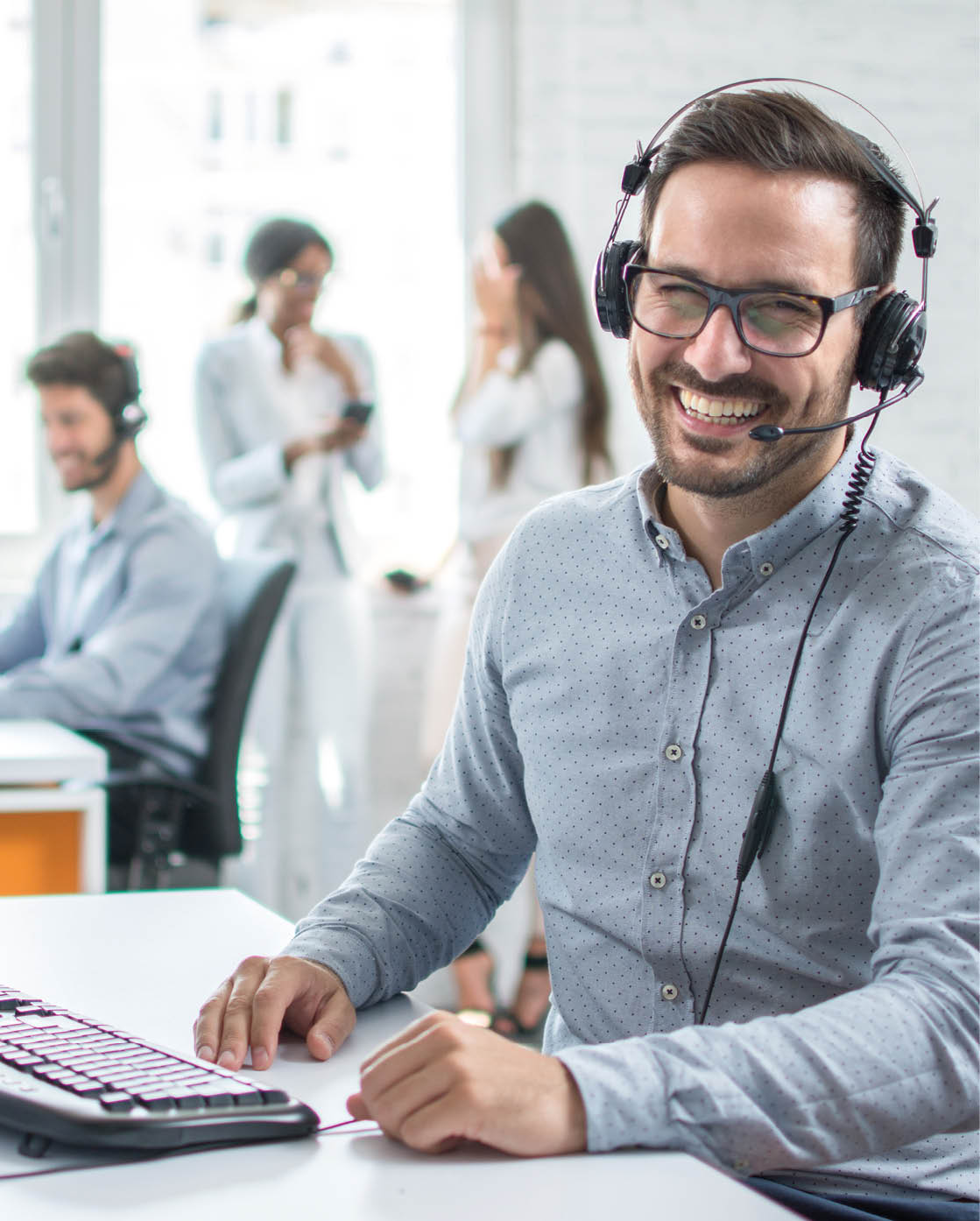 Happy young male customer support executive working in office.