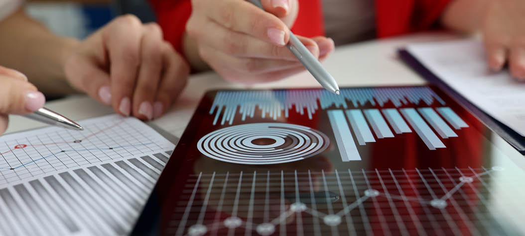 Business women studying charts and diagrams on digital tablet closeup. Business meetings concept