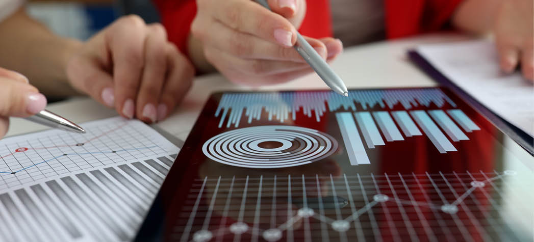 Business women studying charts and diagrams on digital tablet closeup. Business meetings concept