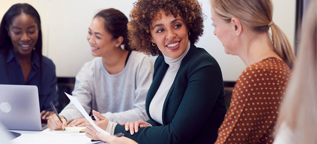Group Of Businesswomen Collaborating In Creative Meeting Around Table In Modern Office