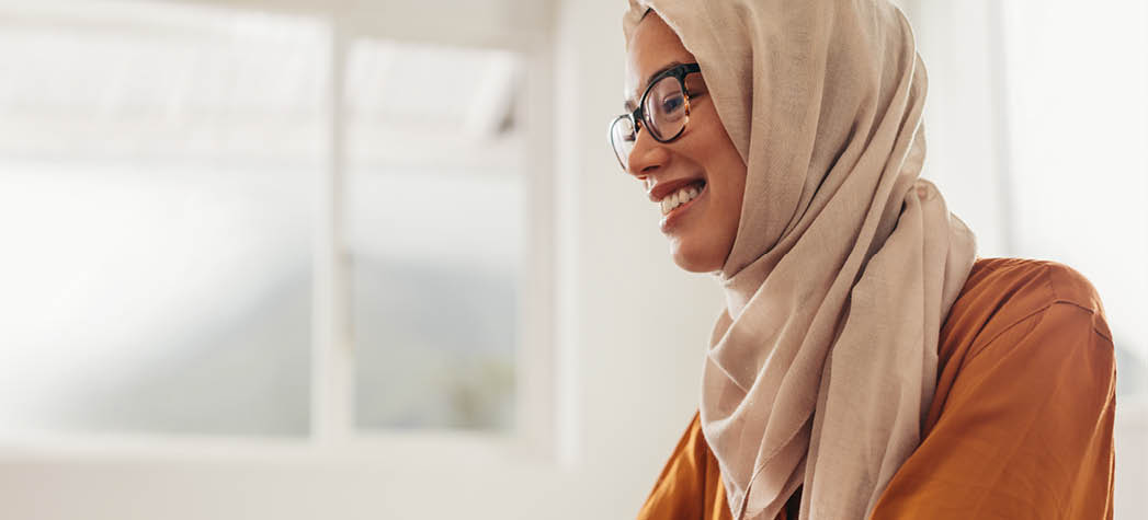 Muslim businesswoman working from home. Woman sitting at home using a laptop.