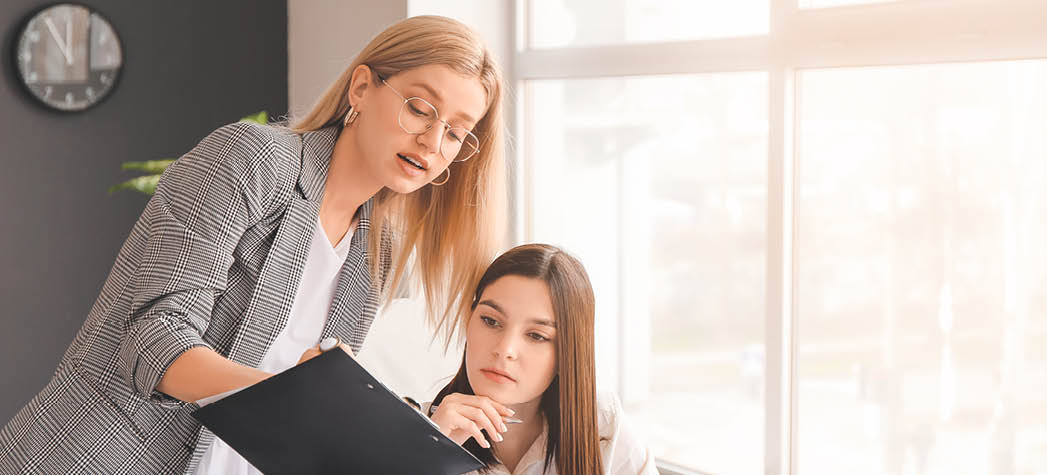 Young female accountant with colleague working in office