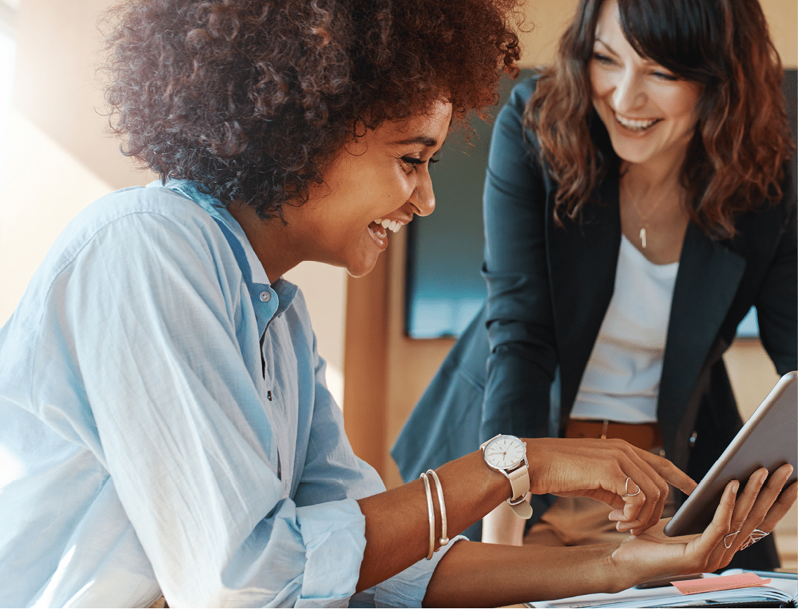 Shot of two businesswoman working together on digital tablet. Creative female executives meeting in an office using tablet pc and smiling.